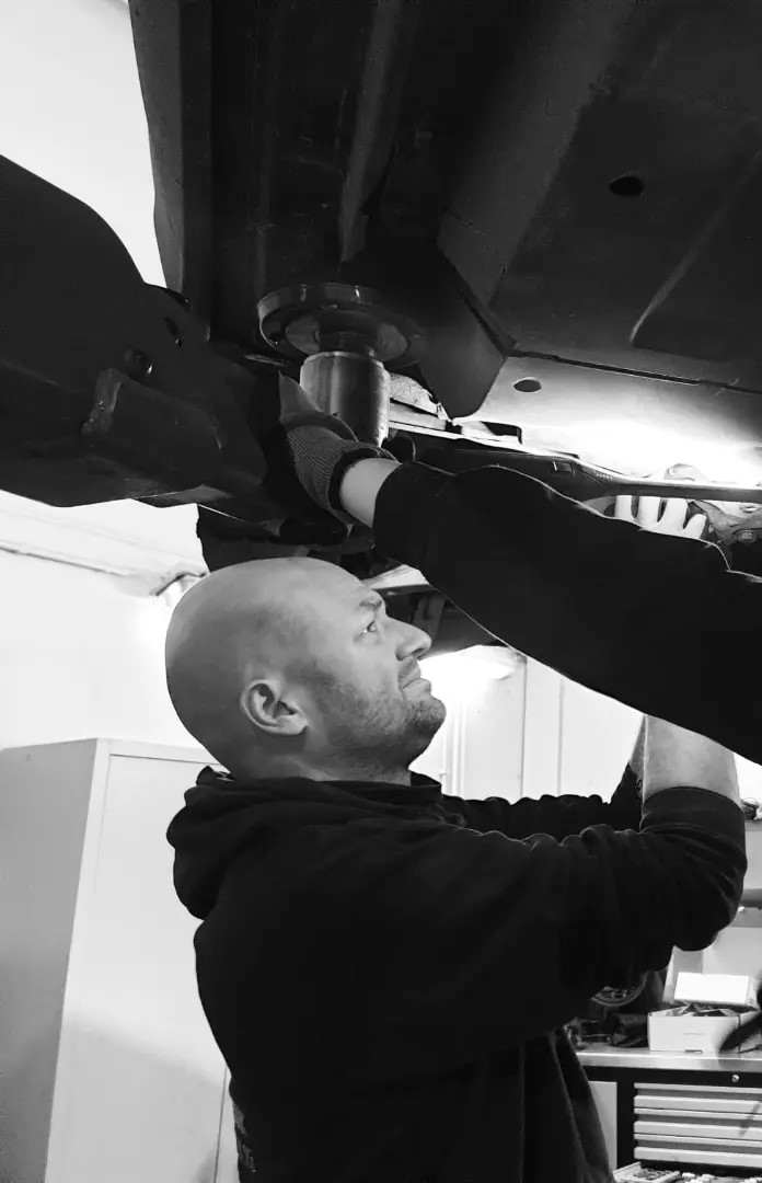 Een foto van Hendrik die aan een auto werkt.